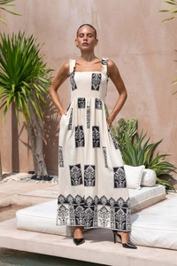 Detailed macro view of the black ethnic print on the white smocked strapless dress