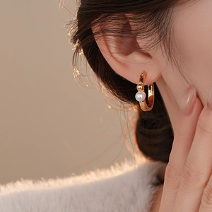 Détail de la boucle d'oreille géométrique plaquée or 14K avec finition polie et perle