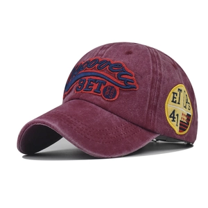 Detail of vintage burgundy washed cotton baseball cap with retro 3D embroidery and badges
