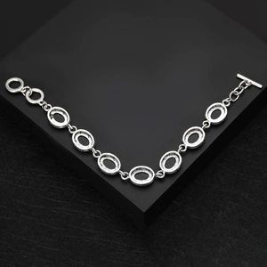 Vintage silver-tone bracelet featuring oval links and a toggle clasp on a dark background
