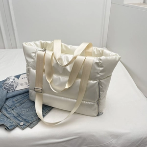 Detail of cream-colored padded nylon fitness bag with reinforced handles and metal zipper