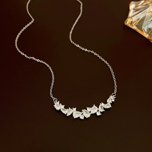 Détail du collier de zircons étincelants en forme de goutte d'eau sur fond de cuir sombre