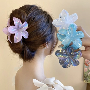 Detailed view of iridescent flower hair claws in purple, white and blue colors
