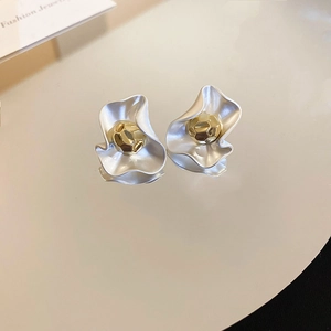 Macro detail of gold and silver plated flower stud earrings with fluid metallic texture