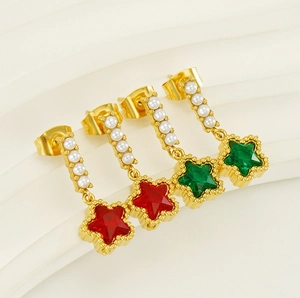 Star-shaped gold earrings with colorful stones and pearls shown on a textured background