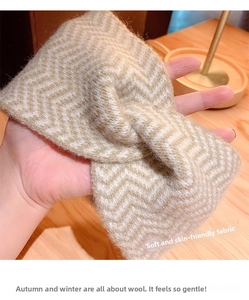Detail of soft beige and brown wavy knitted headband held over a warm wooden desk