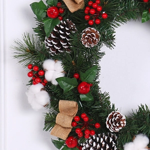 Linen and cotton Christmas wreath with pine cones and red berries for home decor