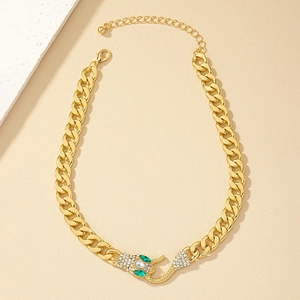 Close-up of gold Cuban chain necklace featuring green and white rhinestone snake pendant
