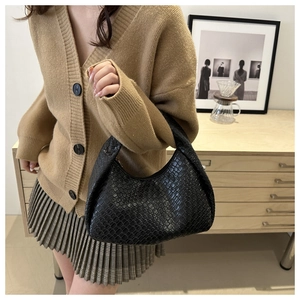 Dettaglio borsa tote nera in ecopelle intrecciata con trama fine e design a mezza luna