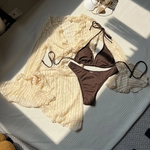 Detail of four-piece bikini set with brown ribbed fabric and white lace cover-up