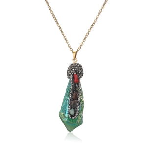 Macro detail of natural green crystal pendant with colorful stones and gold chain