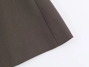 Close-up of deep brown twill fabric texture and high-quality stitching on the skirt suit