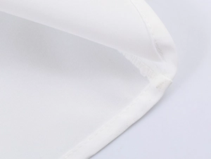 Gros plan sur les coutures de qualité supérieure d'un chemisier blanc sans manches