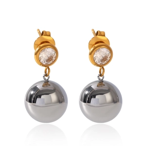 Detail of two-tone ball earrings featuring a gold ring with zircon and silver sphere