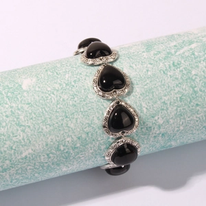 Detail showing vintage heart bracelets with black stones and engraved silver settings