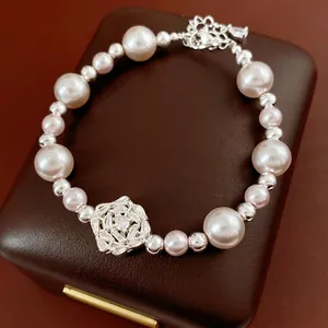 Elegant pearl bracelet with zircon flower charm and silver beads on leather jewelry box