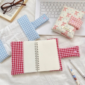 Detail of fabric planner cover with bow design, binder rings and retro stationery props