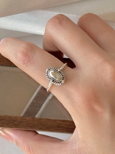 Macro shot of 925 silver oval ring with vintage rope texture edge on female finger