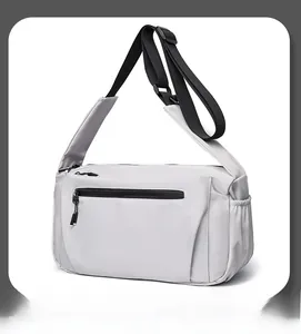 Close-up of light grey waterproof crossbody bag with black adjustable strap and side pocket