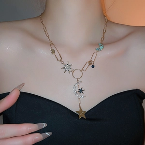 Détails macro d'un collier pendentif étoile lune doré avec cristaux et chaîne épingle