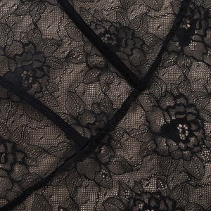 Vue macro de la dentelle florale noire brodée avec détails de la doublure couleur chair