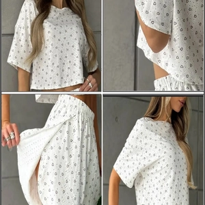 Weißes Lounge-Set mit Herzprint, Kurzarm-Oberteil und strukturierter Hose vor grauem Hintergrund