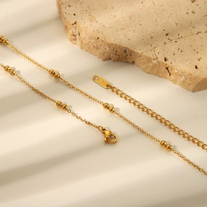 Detail of gold beaded stainless steel multilayer chain with lobster clasp and extender