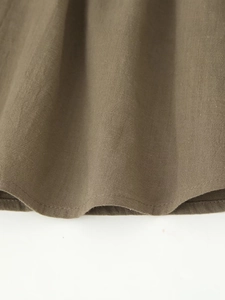 Détail macro de la texture en lin vert militaire et de l'ourlet à double couture