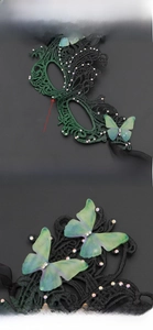 Close-up of black lace masquerade mask with green butterflies and sparkling rhinestones