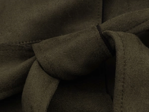 Vue macro de la texture du tissu en suédine et détail du nœud de ceinture du manteau