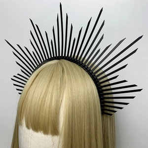 Detail view of a gothic black spiked crown headband worn on a blonde mannequin hair