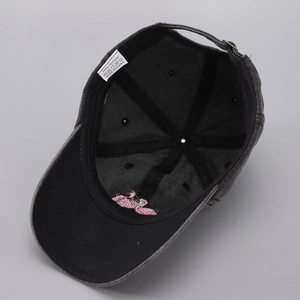 Detailed interior of washed black cotton baseball cap showing 100% cotton label and stitching