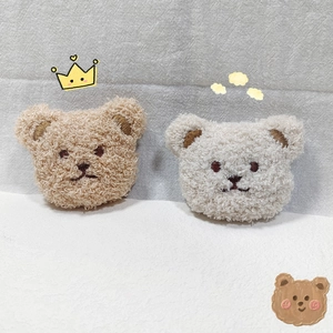 Detail of plush bear head accessories in brown and cream teddy fleece material
