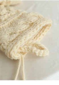 Close-up of cream chunky knit Christmas stocking with cable pattern and hanging loop