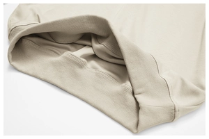 Détail macro du poignet côtelé beige et des coutures plates de qualité sur le sweat
