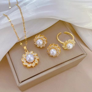 Elegant gold pearl jewelry set including necklace, earrings and ring on silk background