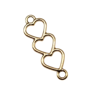 Macro detail of gold triple heart hollow connectors for DIY jewelry making