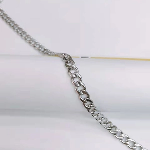 Macro detail of silver stainless steel Cuban link chain with a high-polished metallic finish