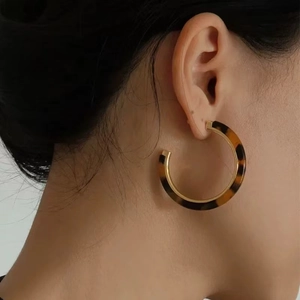 Vintage tortoiseshell resin C-shaped hoop earrings for women worn by a model