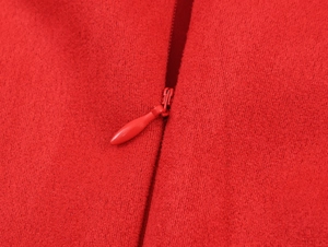 Détail macro d'une fermeture éclair invisible sur une robe rouge en daim doux