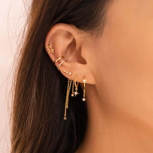 Macro detail of gold star and moon tassel earrings with sparkling zircon stones