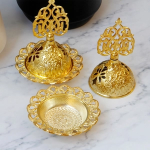Détail d'un brûleur d'encens en métal doré évidé avec des motifs ethniques du Moyen-Orient