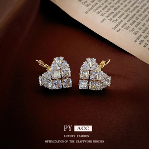 Boucles d'oreilles cœur dorées avec oxydes de zirconium sur fond vintage élégant