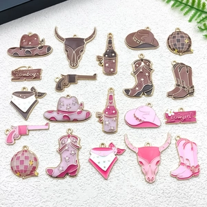 Detail of pink and brown enamel cowboy charms including boots, hats and skull for jewelry
