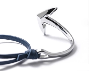 Detailed view of silver metal anchor hook and braided blue leather rope bracelet