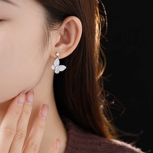Close-up of elegant silver butterfly earrings with sparkling cubic zirconia on a model