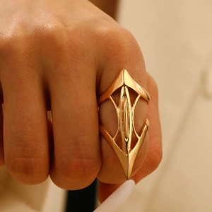 Close-up of a wide gold geometric knuckle ring with layered punk design on finger