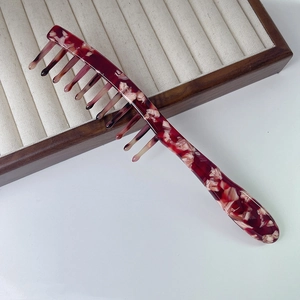Detail shot of vintage acetate wide-tooth comb with red-brown tortoise pattern