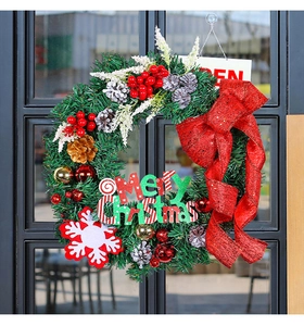 Detailed view of pine needle Christmas wreath with red bow and Merry Christmas sign