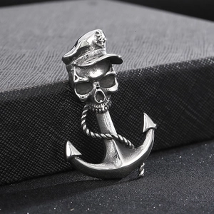 Macro detail of punk skull pendant with captain hat and anchor in polished steel